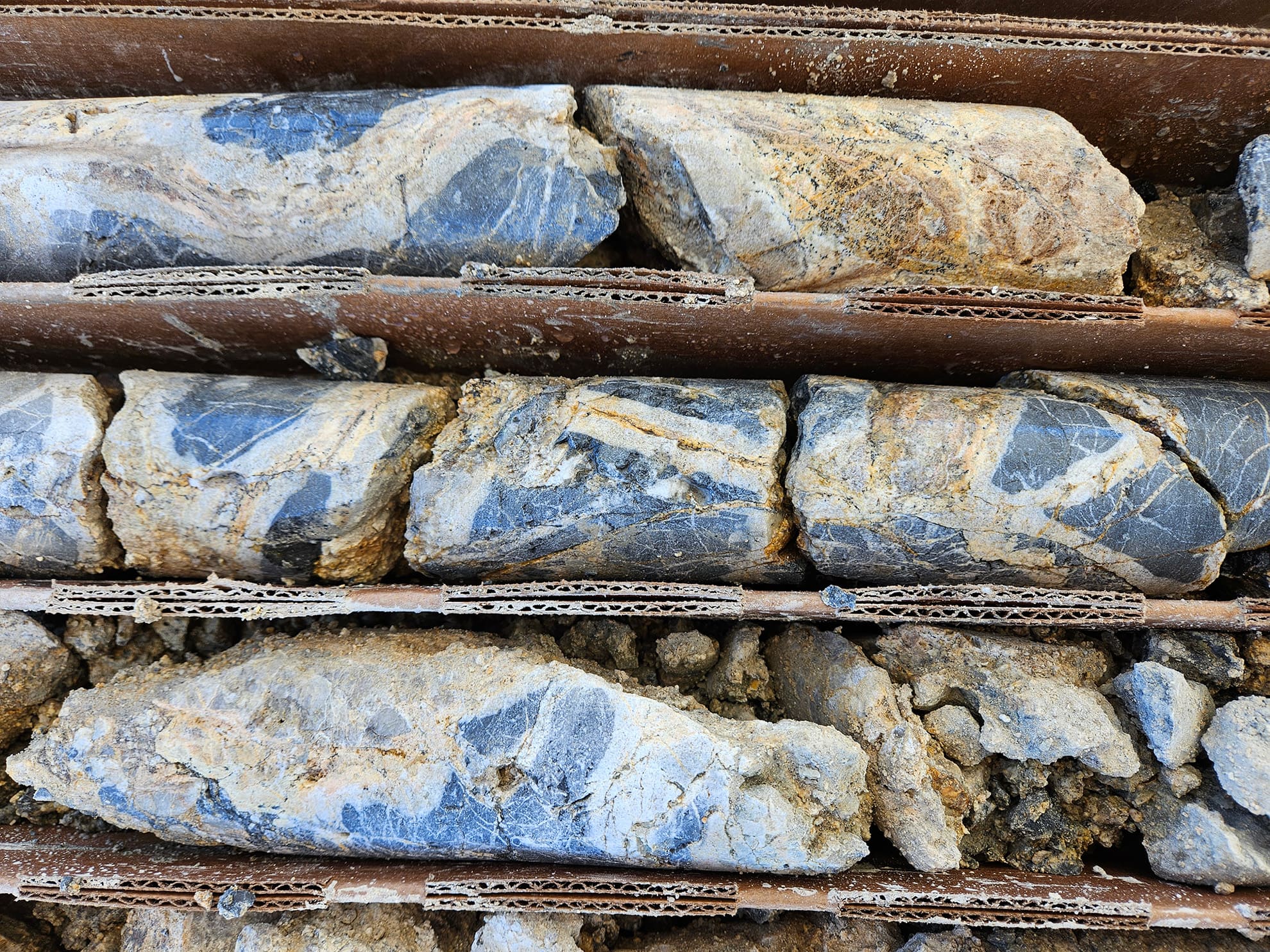 NB26-003; 007 m. Sinuous and planar, cm-scale stockwork crack-seal veins of quartz-garnet-sulfide in dark grey, completely recrystallized marble.